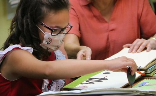 Aitana, una de las alumnas de Primaria de Mar del Blanco, explora un libro infantil adaptado para ciegos (Foto publicada en @ leonoticias.com)