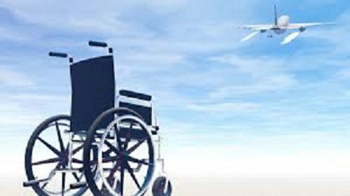 Silla de ruedas en primer plano, con un avión de fondo