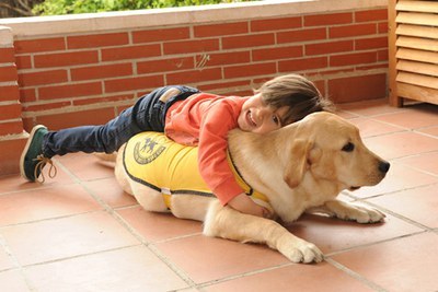 Niña jungando con un perro guía