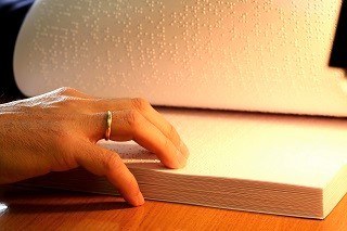 Una persona lee un documento en braille