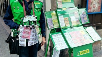 Un vendedor con su expositor portátil con toda la gama de productos de juego extendidos