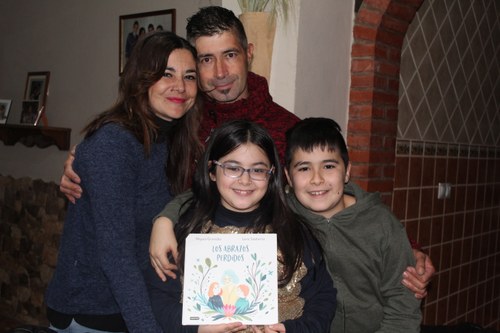 La familia Granados Sánchez muestra con orgullo el cuento 'Los abrazos perdidos', de Nayara