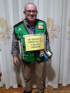José Hernández Varas con su cartel amarillo, productos de juego de la ONCE y el TPV en mano