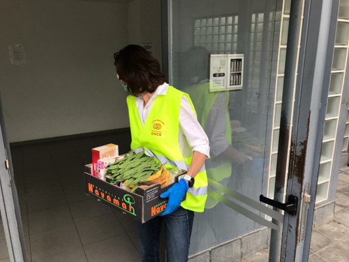 Una voluntaria de Fundación ONCE entregando alimentos