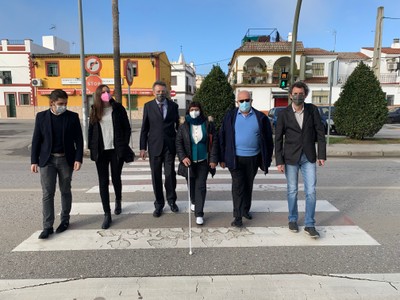 Afiliados y responsable de la ONCE junto al edil de La Rinconada, realizando el cruce un paso señalizado por uno de estos semáforos