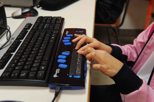 Una niña ciega utilizando la línea braille en su ordenador