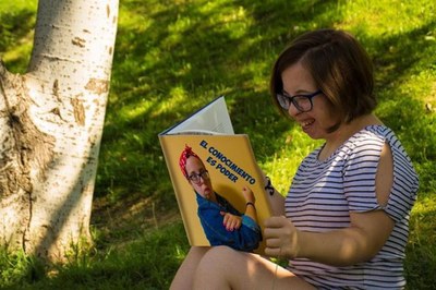 Joven con discapacidad leyendo un libro. Imagen de la exposición fotográfica de la FCM