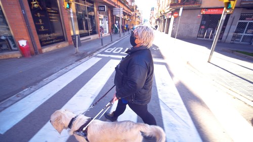 Pamela Díaz cruza con su perro guía el semáforo sonoro de la calle Sant Pere Ullastre (Foto de C. Díaz)