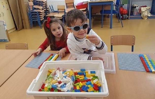 Dos pequeños, uno afiliado a la ONCE, juegan con las nuevas piezas Lego para aprender Braille
