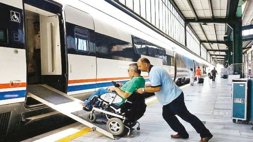 Servicio de asistencia a un pasajero con discapacidad en silla de ruedas en una estación ferroviaria