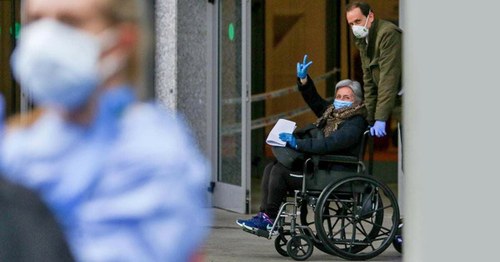 Paciente en silla de ruedas saliendo de un centro sanitario