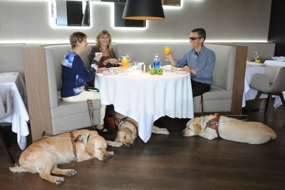 Una familia con sus perros guía en un restaurante