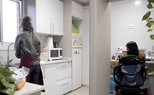 Interior de una vivienda, con una persona en silla de ruedas