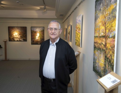 Mariano Herrera posa junto a sus cuadros