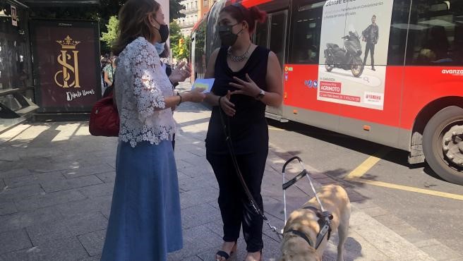 Natalia Chueca y Silvia Borrego charlan junto a uno de los autobuses dotados del sistema Navilens en el acto de presentación