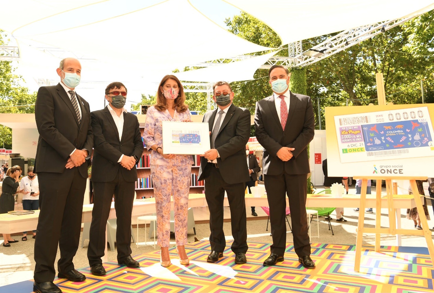 La vicepresidenta de Colombia muestra el cupón dedicado en el acto celebrado en la Feria del Libro de Madrid, flanqueada por Alberto Durán y Ángel Sánchez