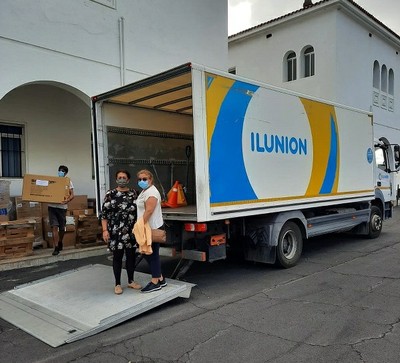 Esmeralda,a la izda., y Juana junto a uno de los camiones de Ilunion que realizan en reparto de gafas y gorras