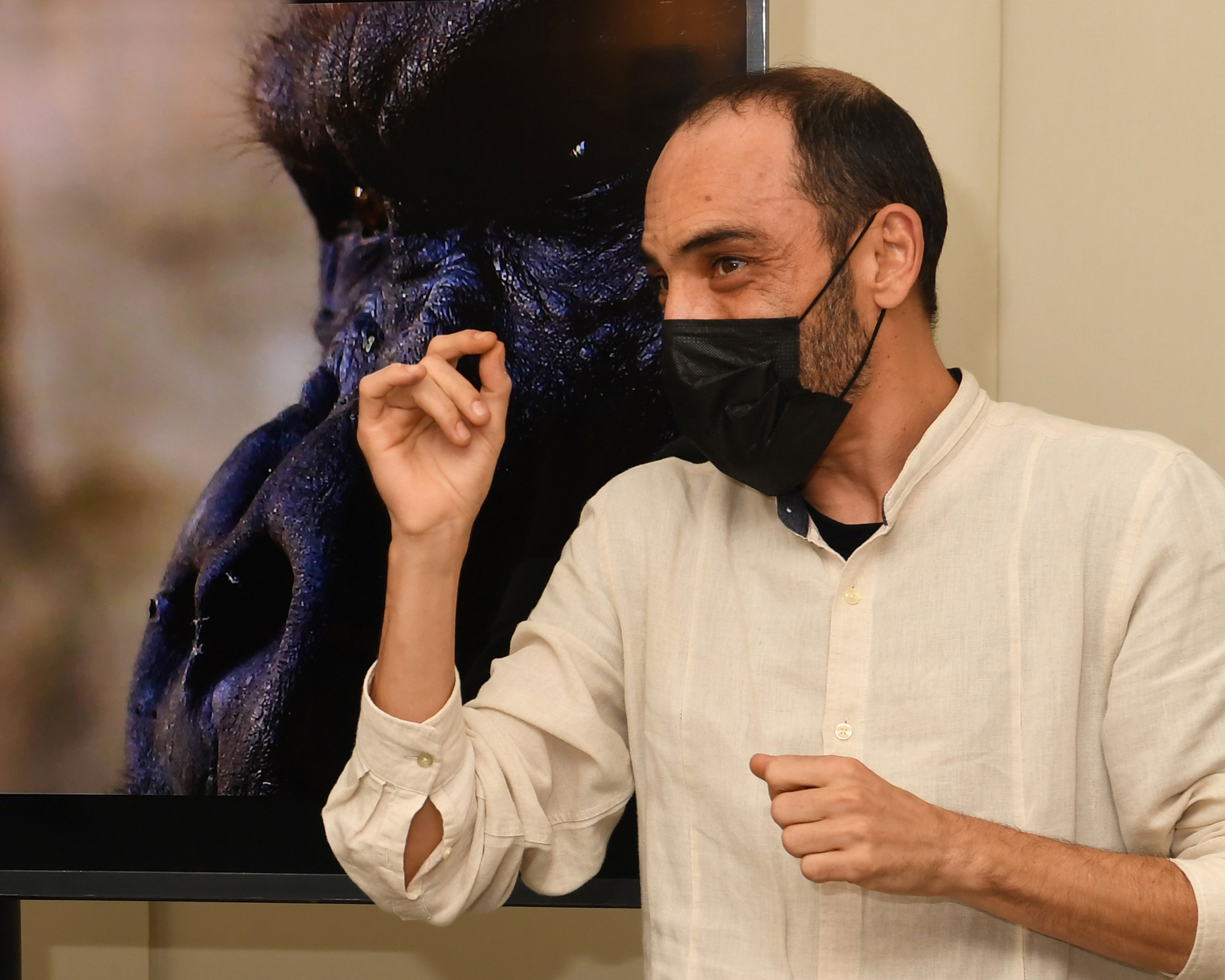 Víctor Meliveo mientras se visualizan imágenes de sus fotografías en la muestra 'fullTIME, the book', en el Museo Tiflológico de la ONCE, y montaje vi