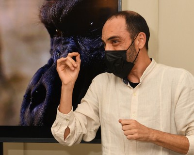 Víctor Meliveo mientras se visualizan imágenes de sus fotografías en la muestra 'fullTIME, the book', en el Museo Tiflológico de la ONCE, y montaje vi