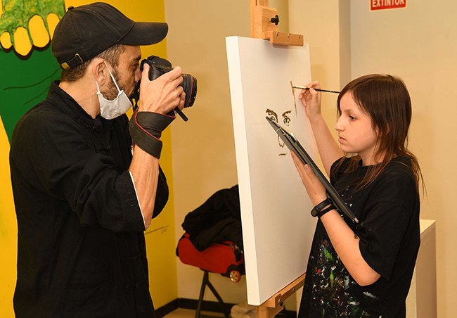 Meliveo fotografía a Andrea mientras ella pinta