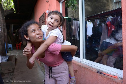 Niña con discapacidad junto a una mujer adulta (Imagen de Unicef)