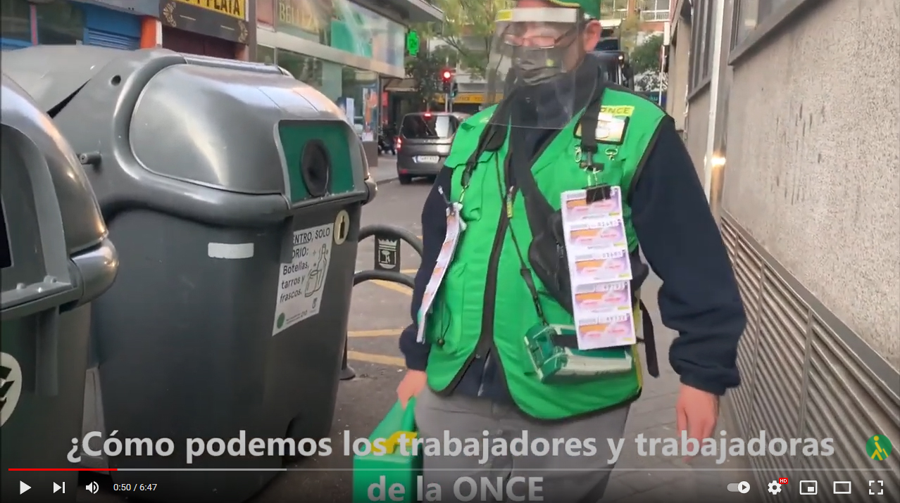 Fotograma del vídeo de la ONCE sobre reciclaje de residuos, con un vendedor que acude a los contenedores de reciclado