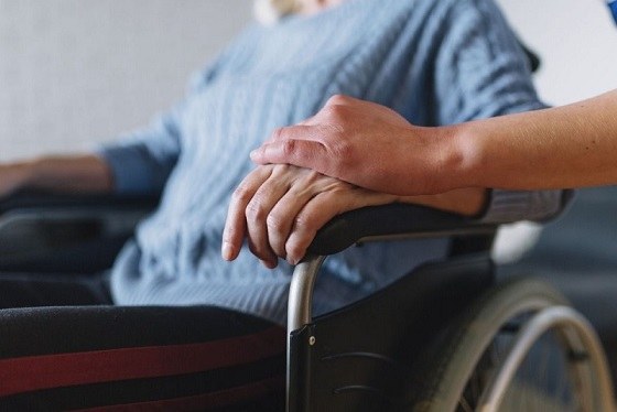 Primer plano de una mujer en silla de ruedas institucionalizada