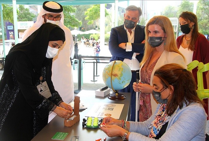Hessa Essa Buhumaid, ministra de Desarrollo Comunitario, en el stand del Grupo Social ONCE, conoce las novedades tiflotécnicas