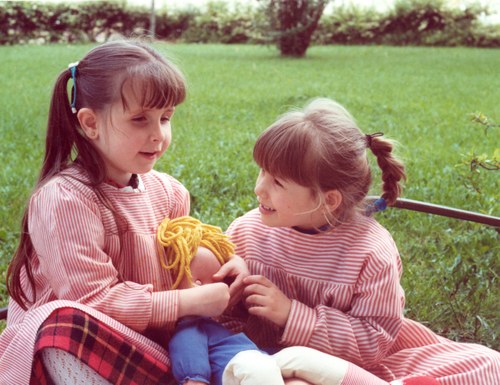 Dos niñas juegan con una muñeca, una de ellas es ciega