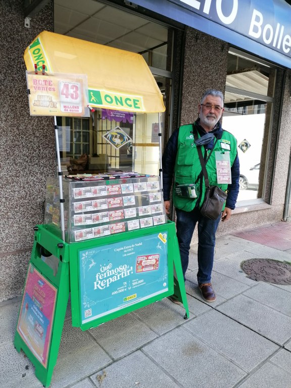 Emilio Carlos García Sánchez posa junto a su expositor de productos de juego responsable de la ONCE 