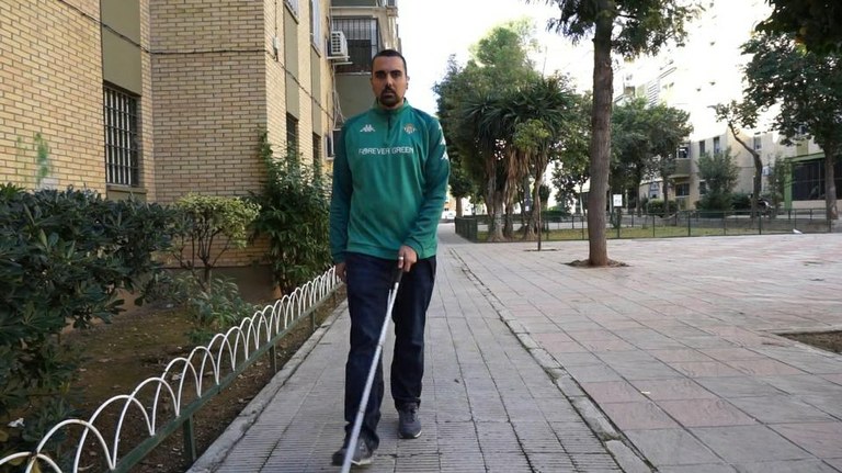 Un aficionado ciego del Betis se mueve con su bastón