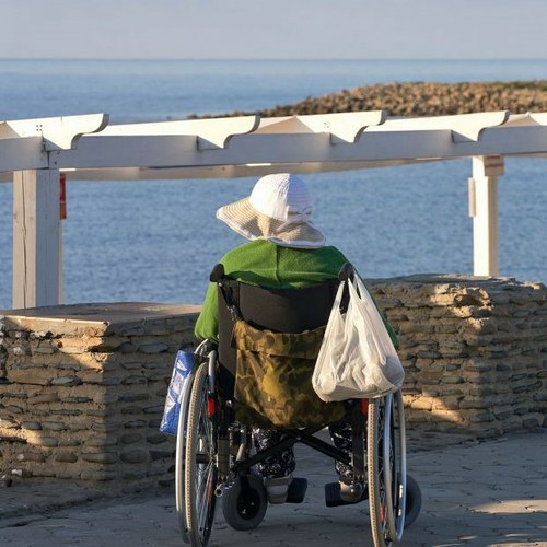 Mujer con discapacidad en silla de ruedas en una playa