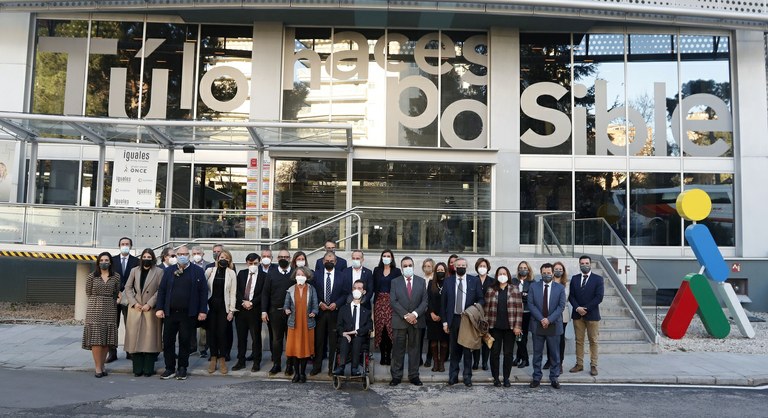 Foto de familia de la comisión junto a los responsables del Grupo Social ONCE y el presidente de CEPES en la entrada de Torre Ilunion