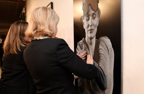 Don personas ante uno de los cuadros de la exposición