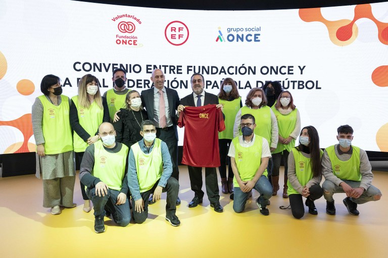 Carballeda muestra la camiseta dedicada junto a Rubiales y voluntarios de  Fundación ONCE