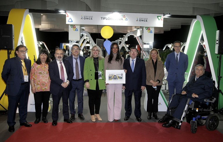 Foto de familia de la inauguración de la feria con la vicealcaldesa mostrando el cupón dedicado