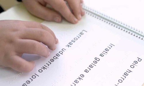 Manos de un niño leyendo braille en euskera