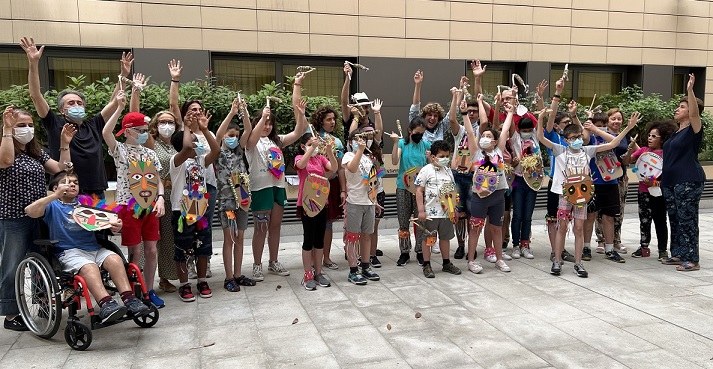 Foto de familia de todo el grupo  de participantes junto a los profesores y las máscaras realizadas