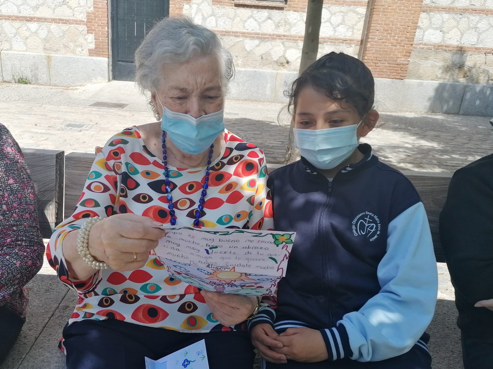 Usuaria del centro de  día muestra la carta escrita por la pequeña alumna del colegio que participa en el proyecto Raíces y Alas