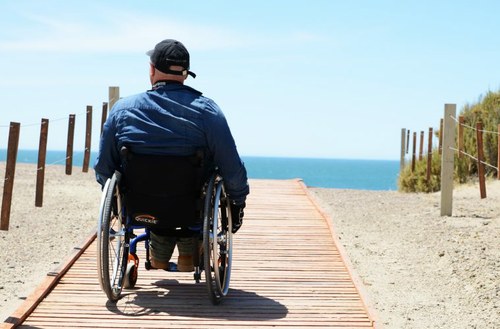 Persona en silla de ruedas en una playa