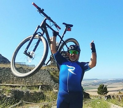 Sergio Cámara levanta triunfal su bicicleta del Gran Reto 