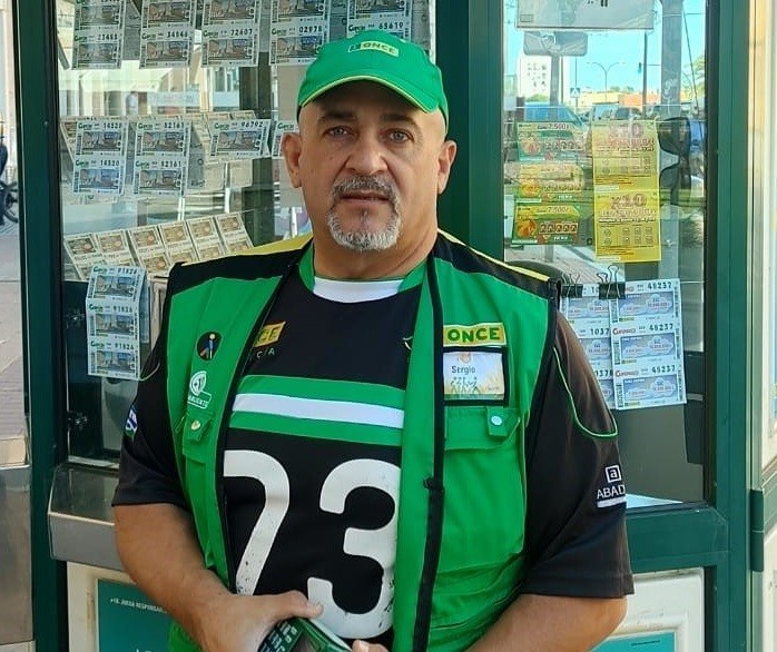 Sergio Cámara posa delante de su quiosco de venta de juego responsable de la ONCE, en San Fernando (Cádiz)