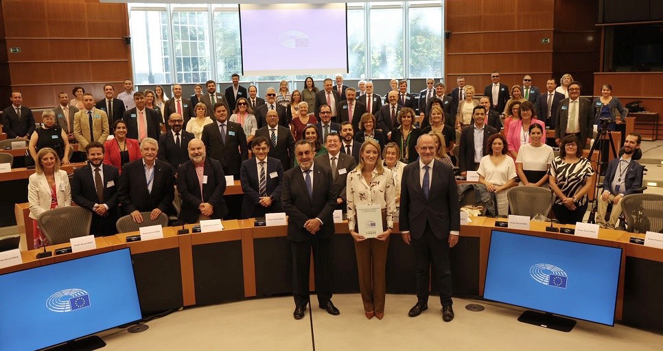 Foto de familia de Metsola junto a Carballeda y toda la delegación del Grupo  Social ONCE, mostrando el acuerdo firmado en el PE