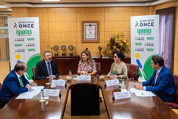 Los participantes en la reunión sentados a la mesa