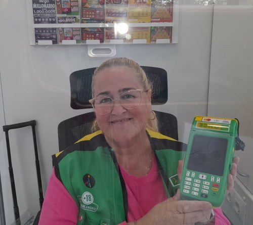Lali Gallego muestra el TPV dentro de su quiosco de venta, en Alicante
