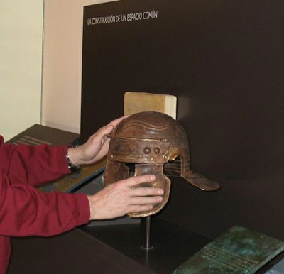Manos tocando una pieza del Museo