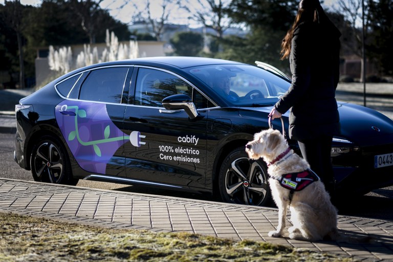 Usuaria con su perro junto a un coche Cabify