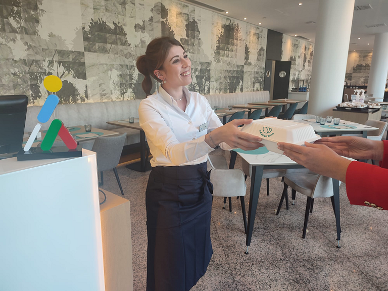 Empleada de un hotel Ilunion entregando un pack de comida