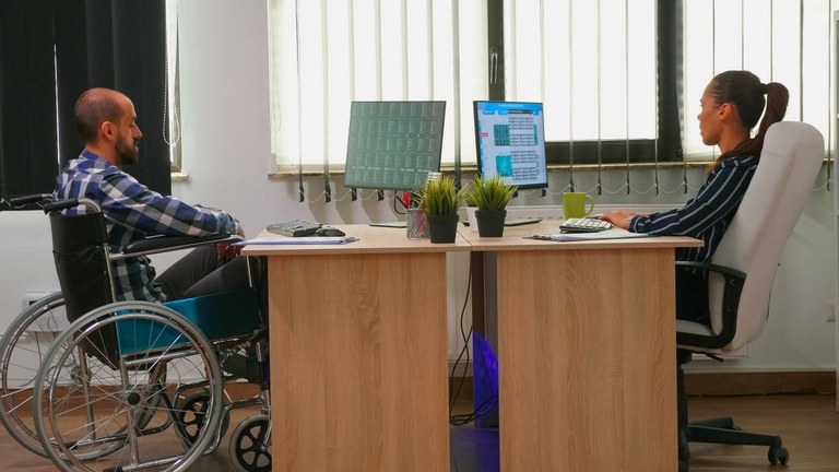 Persona con discapacidad en silla de ruedas en su puesto de trabajo