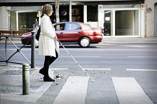 Una mujer ciega camina con su bastón